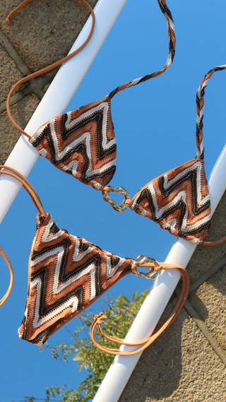 Zigzag patterned bikini top and bottom with gold threading detail.